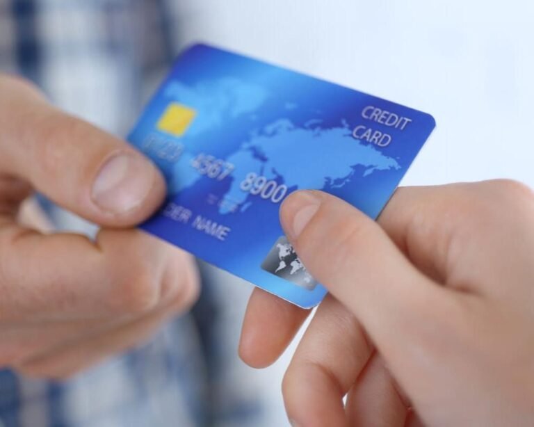 cartao pre pago em maos moedas ao fundo