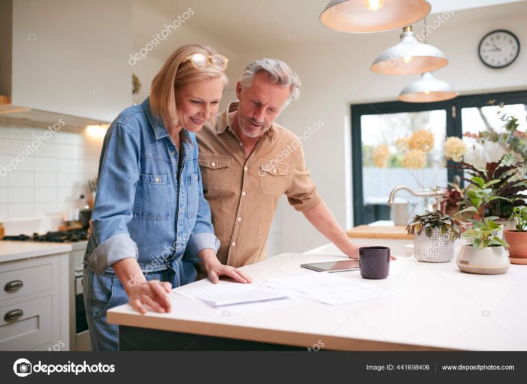 casal sorridente revisando financas juntos