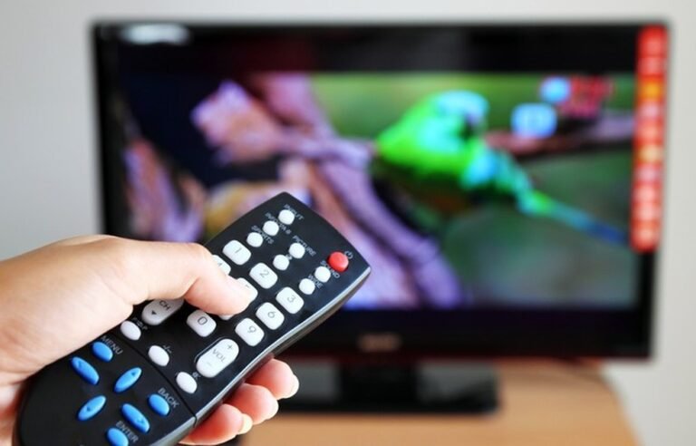 controles remotos e uma televisao ligada