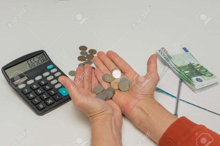 moeda em maos com calculadora ao fundo