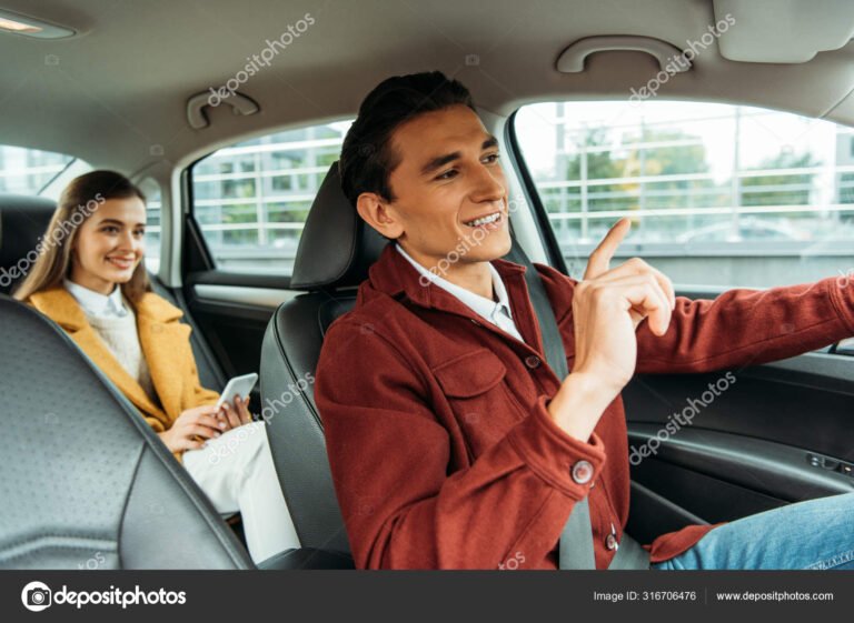 motorista sorrindo dentro de um carro automatico