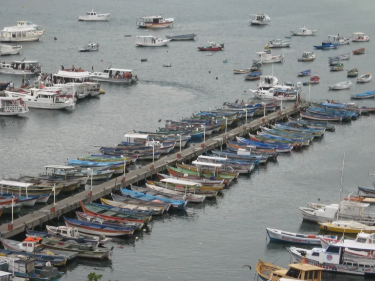 praia dos anjos com aguas cristalinas e barcos