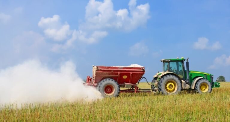 trator aplicando calcario em campo agricola